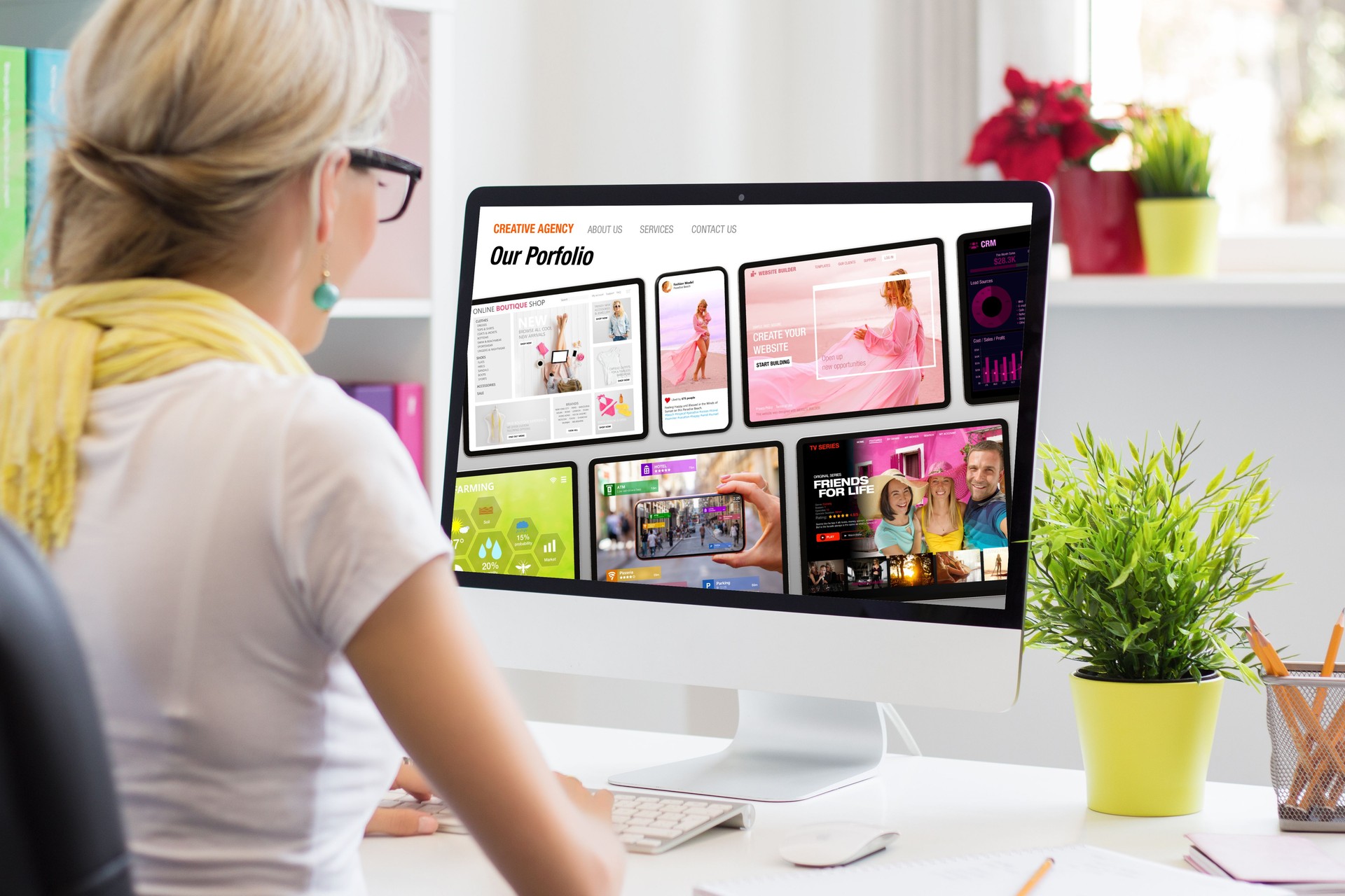 Woman working in office and viewing sample creative agency's website on computer screen